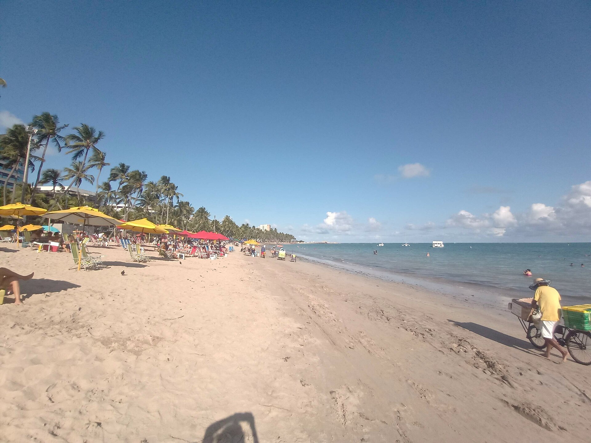 Praia da Pajuçara em Maceió com mar azul e edifícios à beira-mar